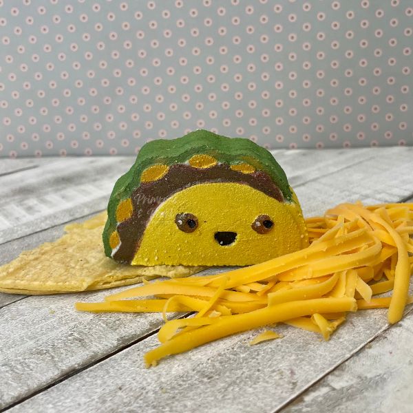Taco shaped bath bomb with shredded cheese and corn tortilla accents